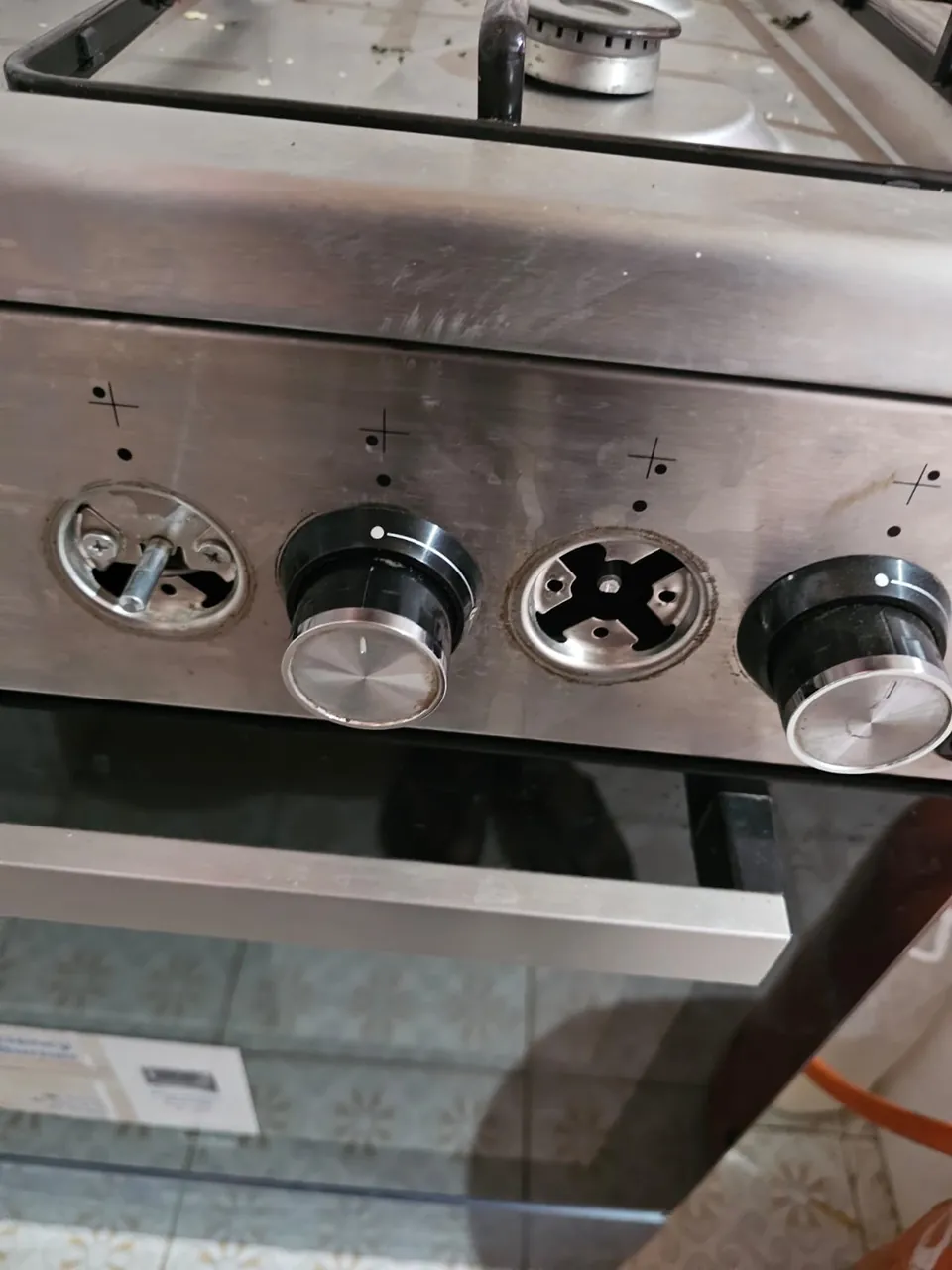 Stainless cooker control panel with the knobs being checked