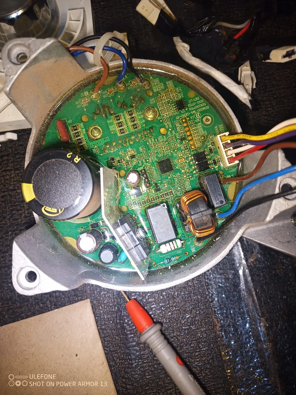 Washing machine motor control board under test with a meter